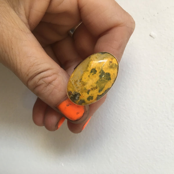 Oval bumblee jasper gemstone ring in gold and silver - in hand