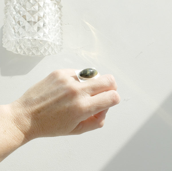 Oval tigers eye gemstone ring set in square sterling silver setting - in light on hand