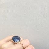 sapphire gemstone ring - faceted semi precious stone in a gold setting with silver ring - on hand in light